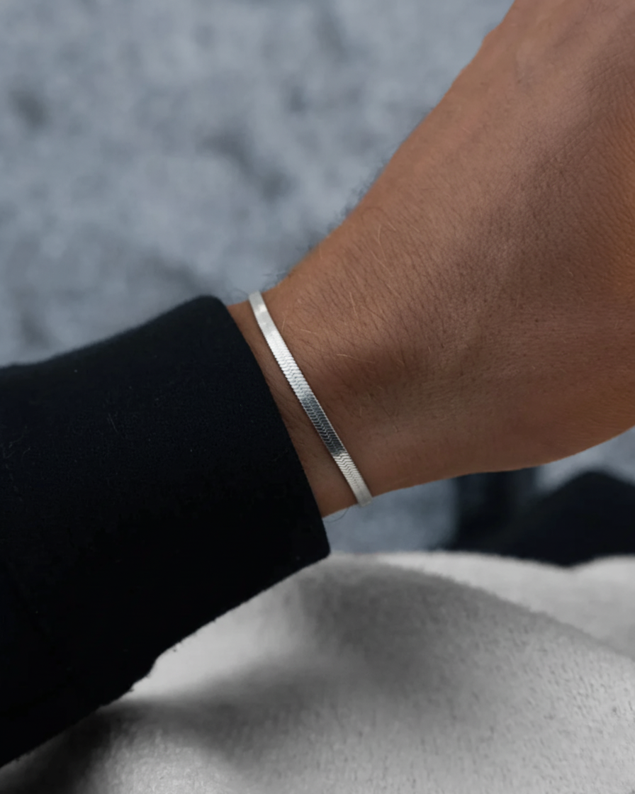 Silver bracelet on a wrist with a blurred background